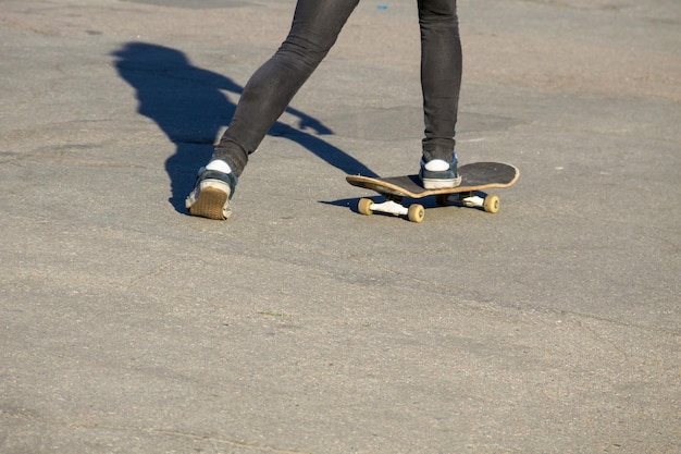 Skateboarderbenen die skateboard berijden bij skatepark