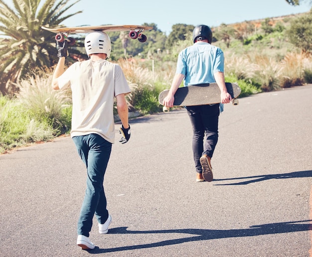 Foto skateboardsporten en vrienden lopen op de weg klaar voor avontuurlijke vrijheid en vrijetijdsbesteding op de berg vriendschapskateboarden en skatermannen met longboard voor schaatsen en fitness