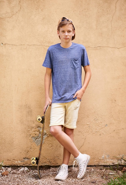 Skater dude Fulllength shot of a teenage boy standing with his skateboard