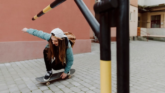 Foto ragazza pattinatrice nell'urbano in sella allo skateboard