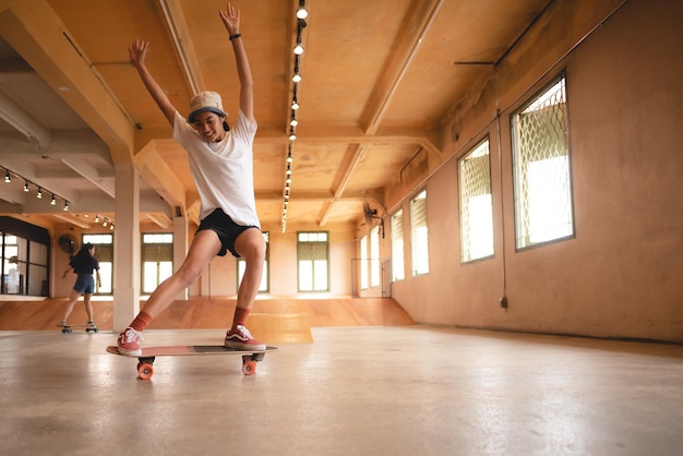 Skater vrouw persoon skateboard spelen in sport sportschool jonge Aziatische vrouw zijn blij en leuk met skateboarden levensstijl in stad tiener hipster vrouwelijke trendy mode