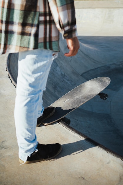 Skater with skateboard on the edge of the pool He is about to jump