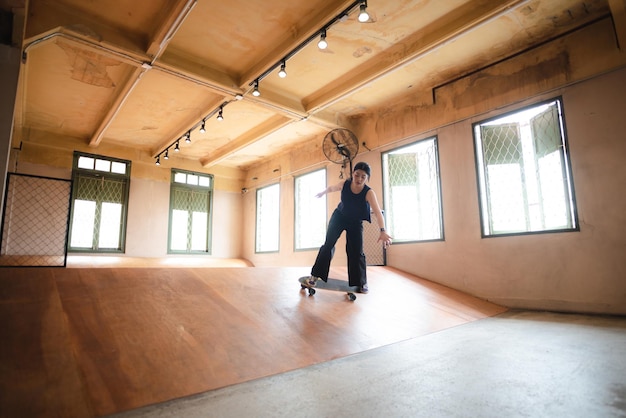 Skater woman person playing skateboard in sport gym young Asian woman are happy and fun with skateboarding lifestyle in city teenage hipster female trendy fashion