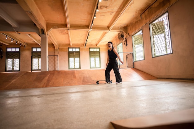 Photo skater woman person playing skateboard in sport gym young asian woman are happy and fun with skateboarding lifestyle in city teenage hipster female trendy fashion