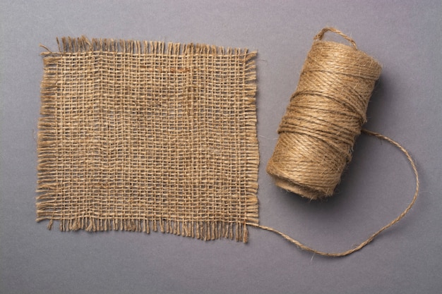 A skein of linen thread and a flap of linen fabric on a gray