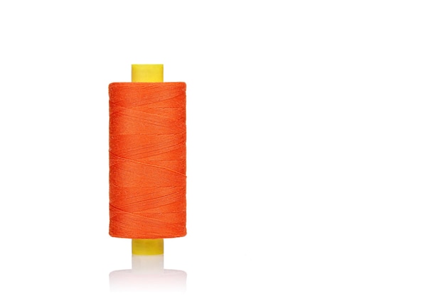 Skein of orange color thread macro on a white background