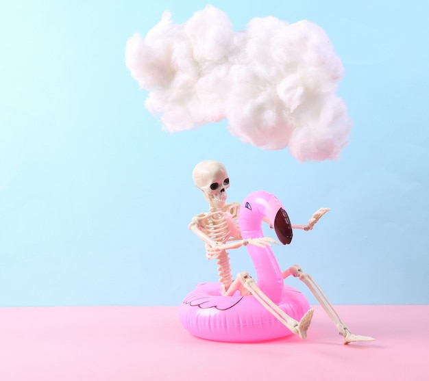 Skelet met opblaasbare flamingo en drijvende pluizige wolk op blauw roze pastel achtergrond concept art minimalistisch idee