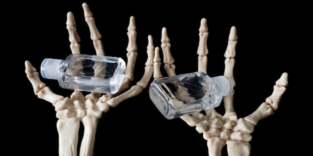 Skeleton Claw Hand holding bottles of Hand Sanitzer during Halloween