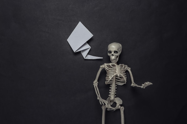 Skeleton with blank dialog cloud on black background