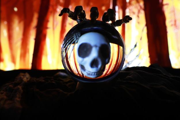 Skeleton Zombie Hand Rising Out Of A GraveYard - Halloween. Mysterious magic ball predictions and smoke on dark scene. Fortune teller, mind power, prediction concept. mysterious background