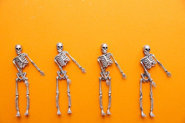 Skeletons dancing on an orange table