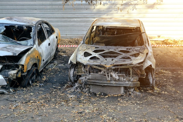 Skeletten van uitgebrande auto's na hevige brand. Brandstichting, kortsluiting van de bedrading.