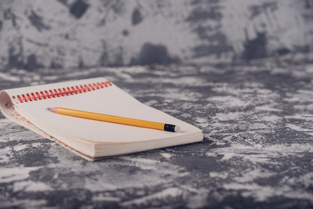 Sketchbook Notepad With Wood Pencil on stone Table Desk Background, loft Style, Concept and Idea for Write Your Text Here.