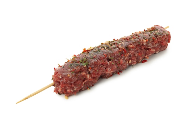 Spiedino con carne macinata cruda o lula kebab isolato sul tavolo bianco