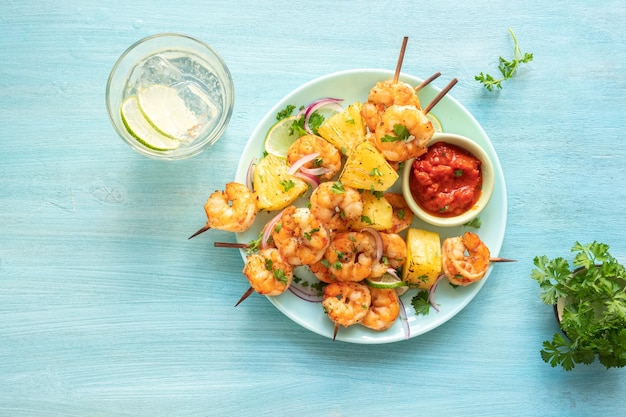 Skewers of barbecued shrimp with a pineapple