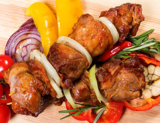 Skewers and vegetables on wooden boards