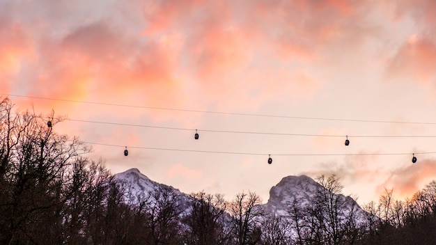 L'ascensore di sci nelle montagne profila contro il cielo drammatico