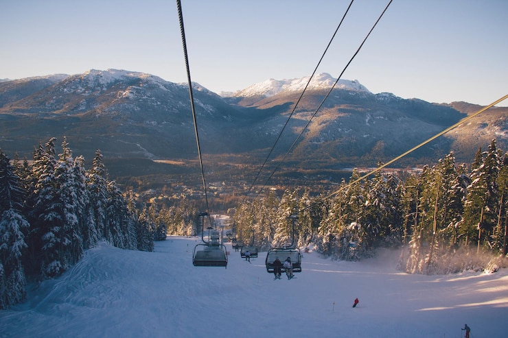 Foto ski-lift over besneeuwde bergen tegen de lucht