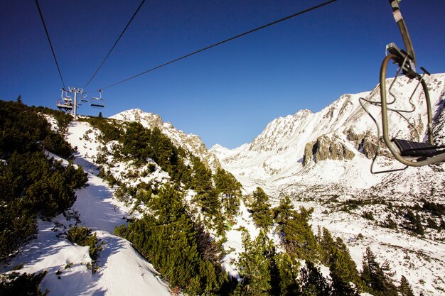 The ski-lift in snowy mountains Tatras on a background of blue sky