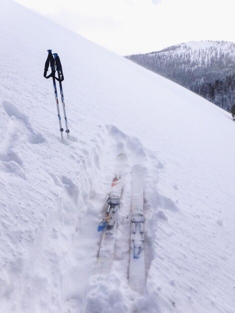 Photo ski and poles on snowcapped mountain