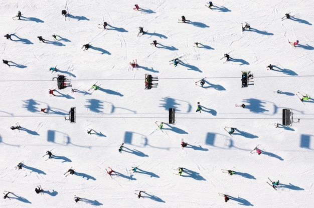 Фото Горнолыжный курорт вид с воздуха на лыжников и сноубордистов зимние виды спорта