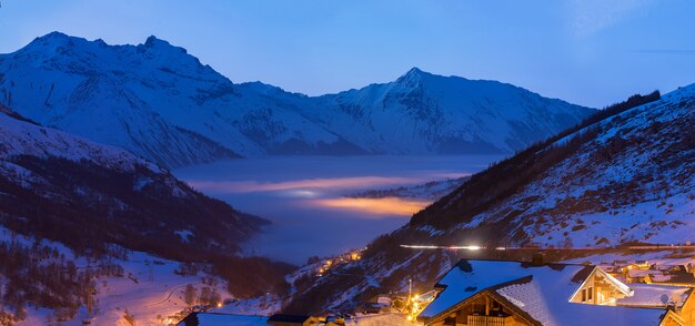 Stazione sciistica con nuvole di mare e grandi montagne