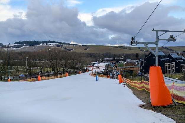 A ski slope with orange snow on the ground and a sign that says ski resort.