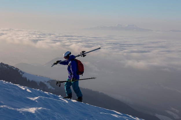 Photo a ski tourist climbs above the clouds