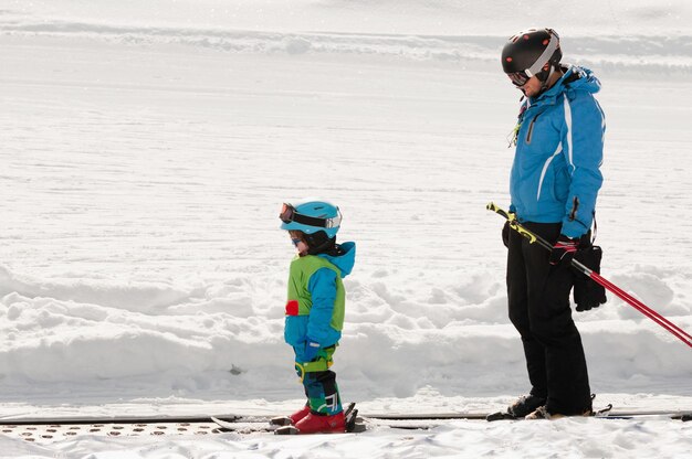 Ski trainer and little boy skiing