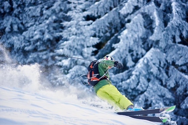 Skiër-backpacker skiën op helling die sneeuwstorm sneeuwpoeder opheft