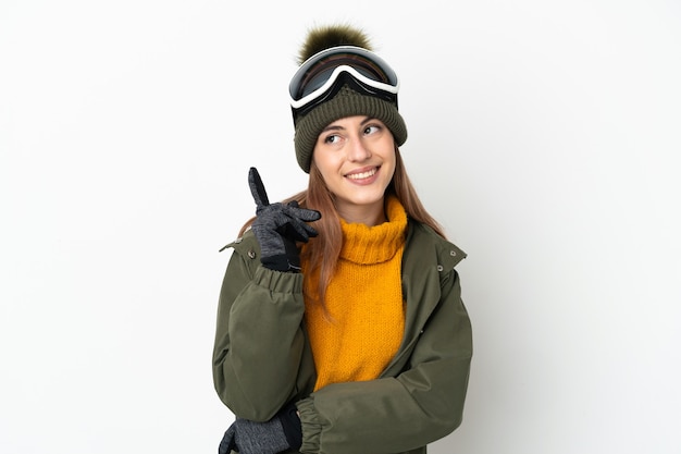 Foto sciatore donna caucasica con occhiali da snowboard isolati su sfondo bianco rivolto verso l'alto una grande idea