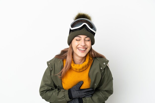 たくさん笑って白い背景に分離されたスノーボードグラスを持つスキーヤー白人女性