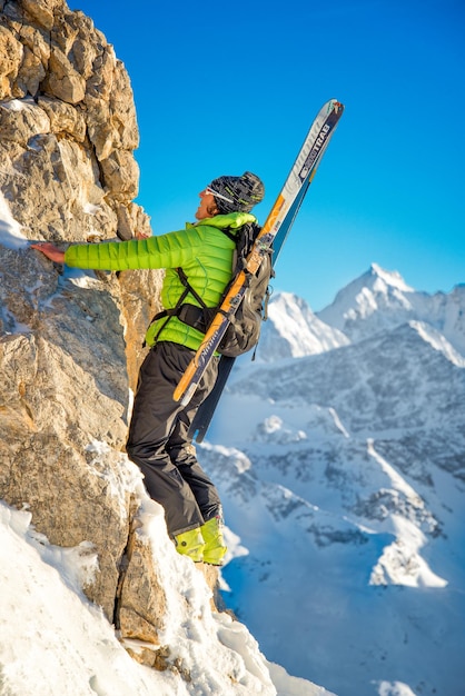 バックパックにスキーを持って登山者をスキーヤー