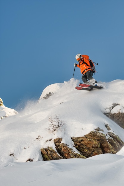 Фото Лыжник спускается над скалой.