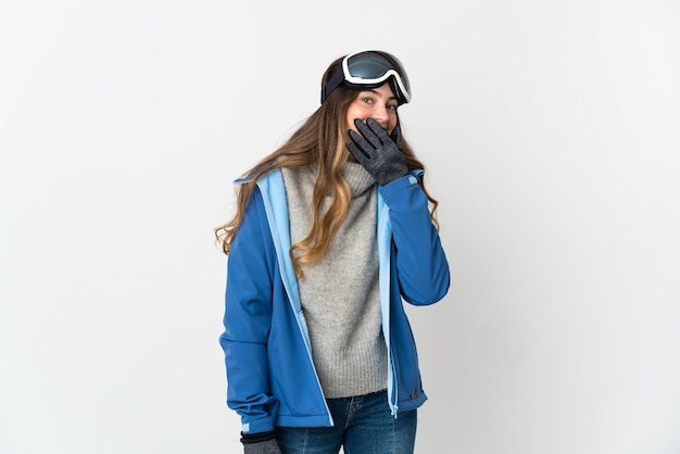 Skier girl with snowboarding glasses on white happy and smiling covering mouth with hand