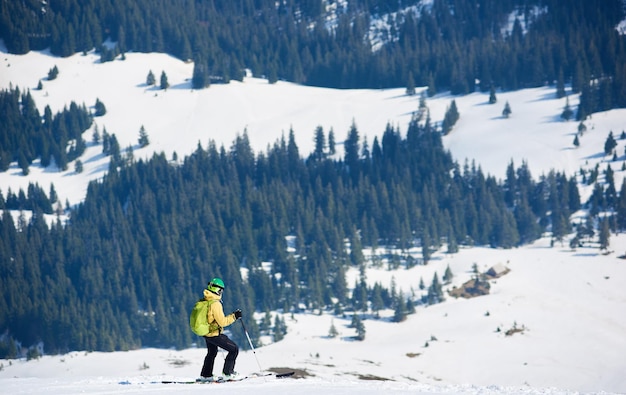 Skier hiker with backpack on skis in deep white snow on background of beautiful winter landscape