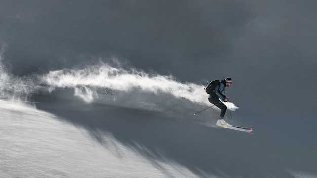 Skiër in verse sneeuw buiten de piste laat een spoor van sneeuw achter