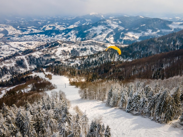 산 스키 슬로프 익스트림 스포츠 위의 스키 패러글라이더