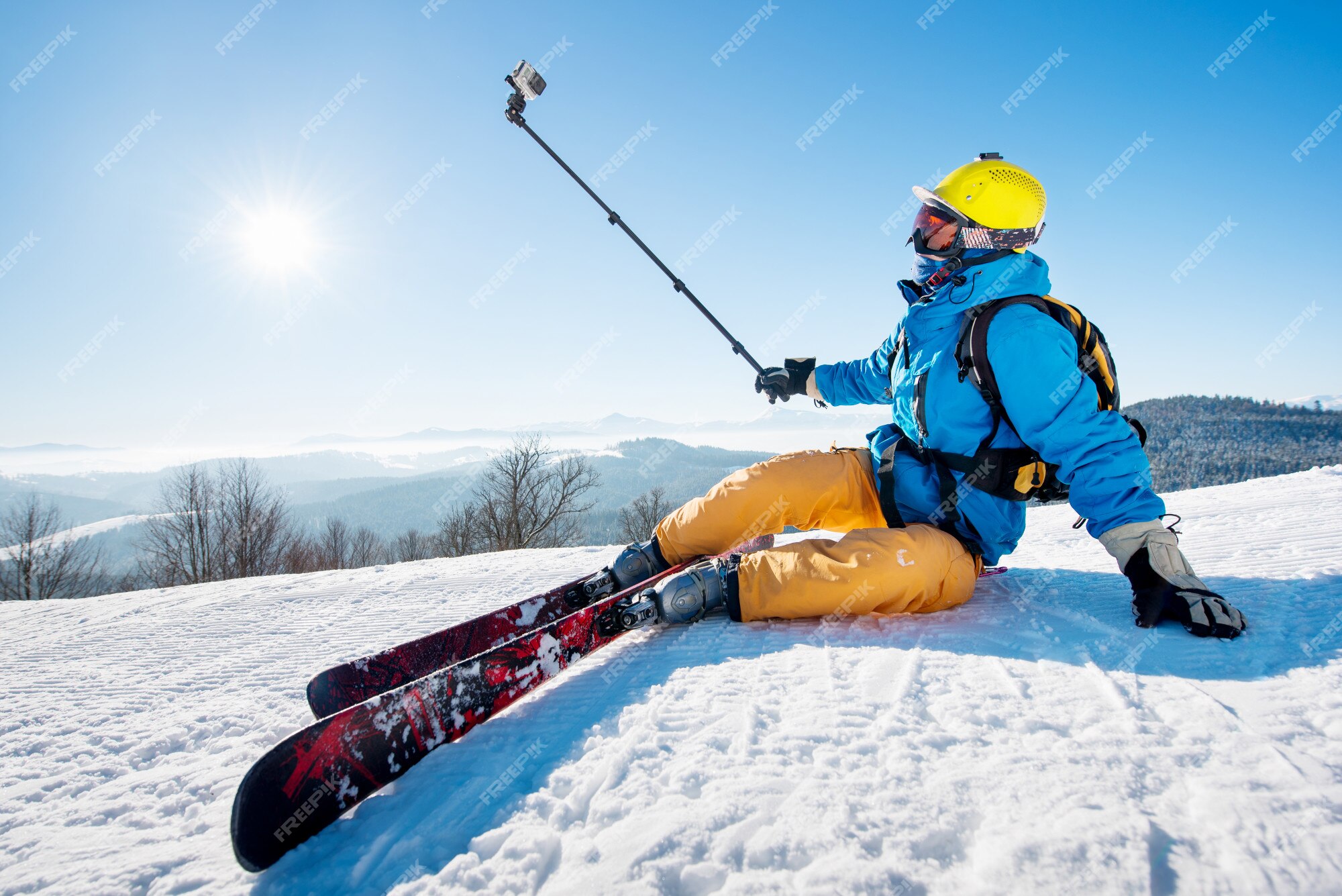 Skinnende dato dis Premium Photo | Skier sitting on the ski slope taking a selfie using selfie- stick. resting relaxing extreme recreation lifestyle activity technology  concept. blue sky with sun and winter forest