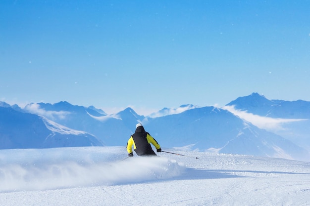 Skiër skiën bergaf in hoge bergen, achteraanzicht, Solden, Austria