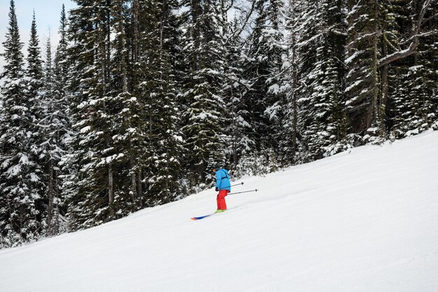 Skiër skiën op besneeuwde berghelling