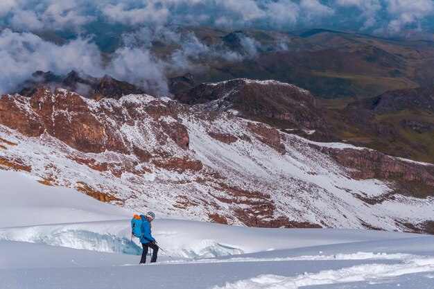 Skier skiing downhill during sunny day in high mountains