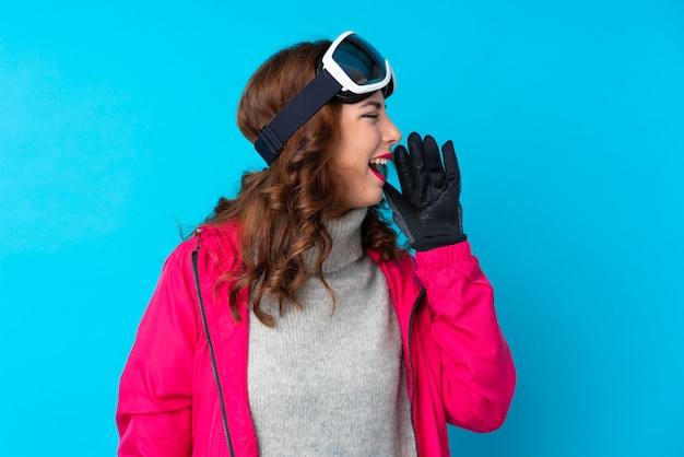 Skier woman with snowboarding glasses shouting with mouth wide open