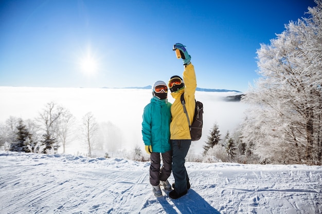 Skiërs die een foto van zichzelf maken met een smartphone over een berg