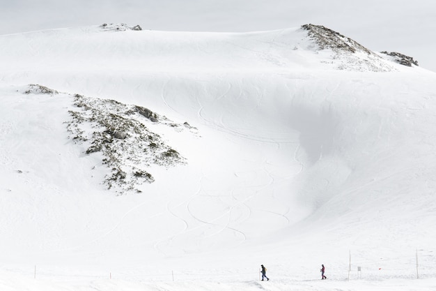 雪に覆われた山脈を歩くスキーヤー