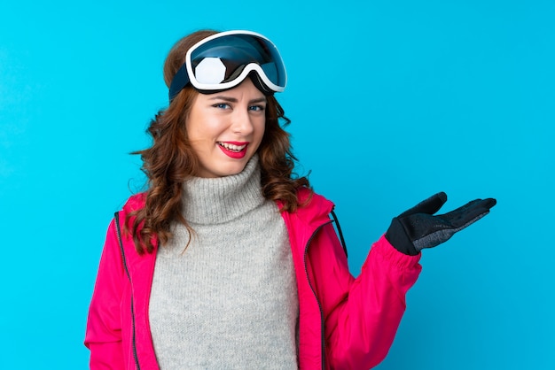 Skiërvrouw met snowboarding glazen over geïsoleerde muur