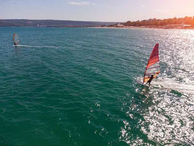 Skiing windsurfing in the sea at sunset