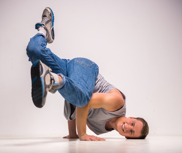 Skilful breakdancer posing on his hands at studio.