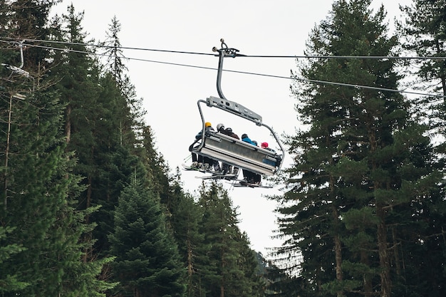 Skilift die mensen opheft in de Balkan, met dennenboom op de achtergrond