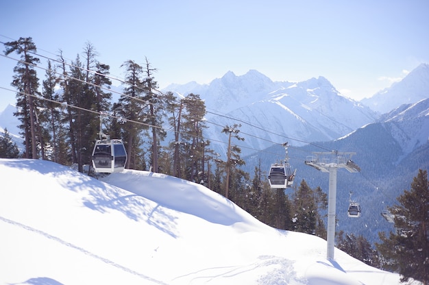 Skilift met stoelen die over de berg gaan en paden vanuit luchten en snowboards.